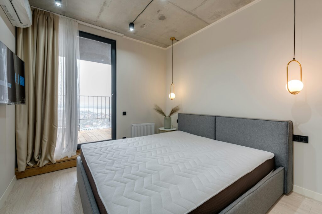 Minimalist bedroom featuring modern furnishings and stylish lighting, ideal for contemporary living.